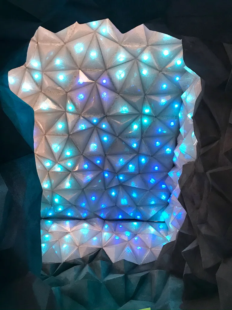 Skulpturale Decke aus dreieckigen Lichtelementen in Eisblau und Weiß mit eingelassenen LEDs