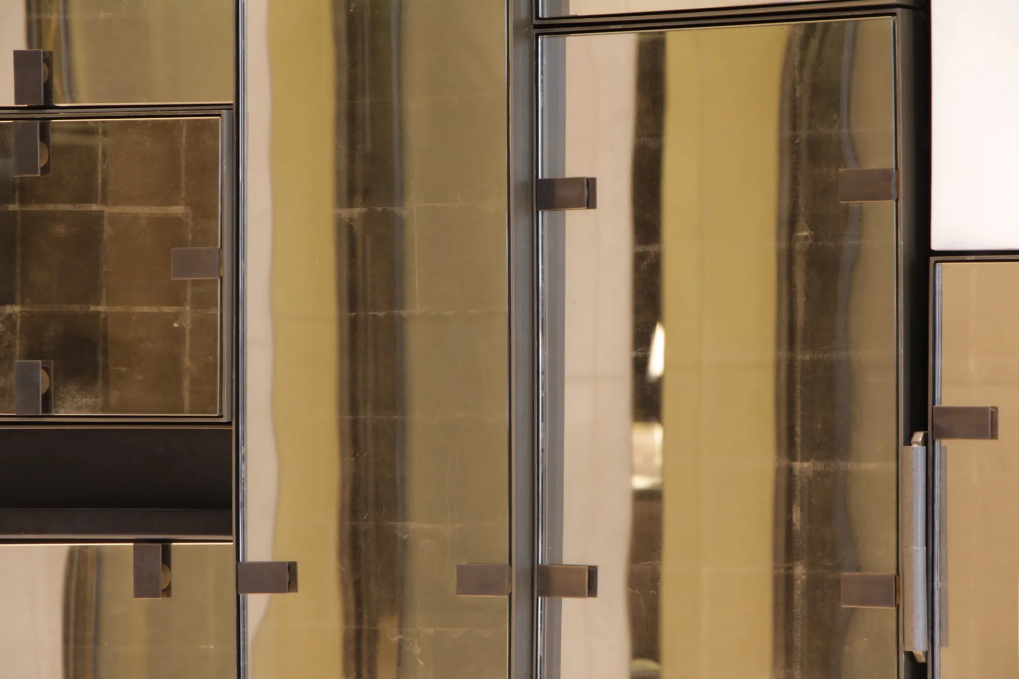 Detail der Mondgold-Glaswand im Waldorf Astoria mit goldfarbenen Spiegel- und Bronzepaneelen
